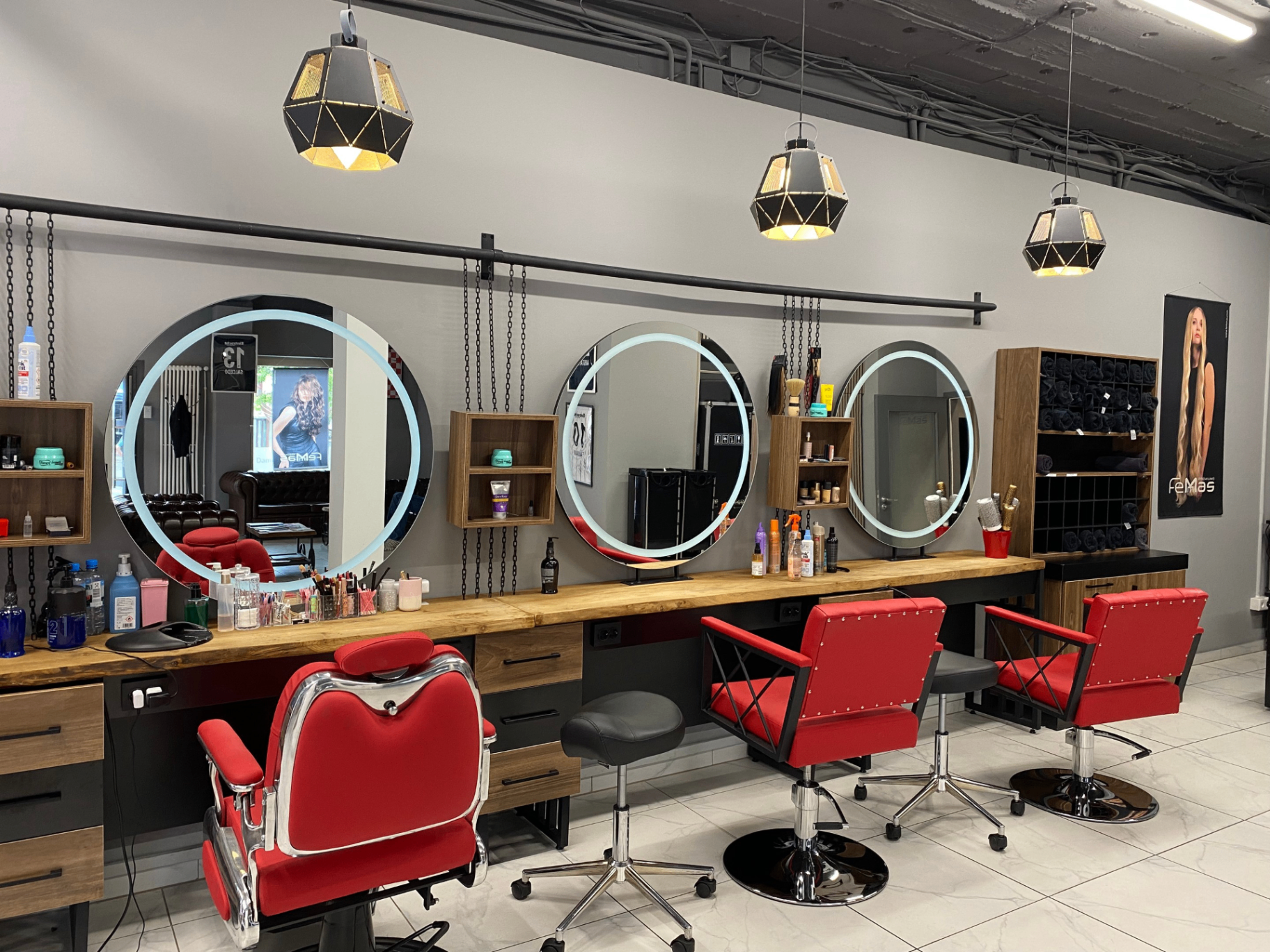 Adler Cut Innenraum: rote Friseurstühle, Spiegel mit LED, schwarze Industrie-Pendelleuchten